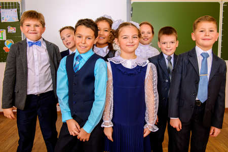 Group of happy classmates in school uniform posing together at a classroom. Education.の写真素材