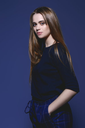 Portrait of a stylish fashion model in casual clothes over gray background. Beauty, fashion concept....