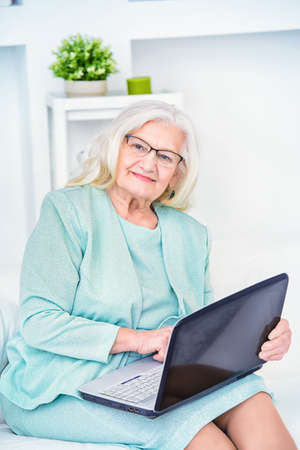 Contemporary senior woman working with laptop at home. の写真素材