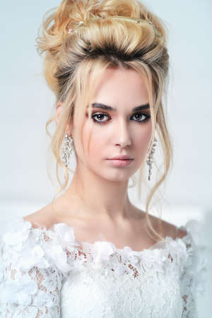Close-up portrait of a beautiful bride woman. Wedding make-up and hairstyle. Jewellery.の写真素材