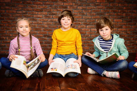 Happy smiling children reading books together. Educational concept. の写真素材