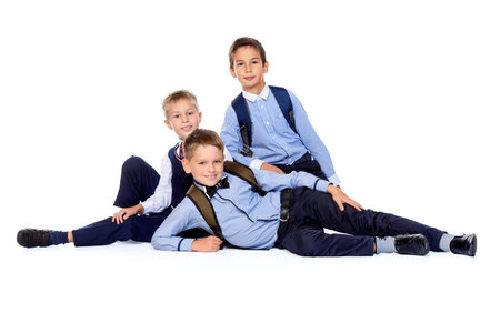 Three schoolboys posing together in school uniform. Educational concept. Isolated over white.