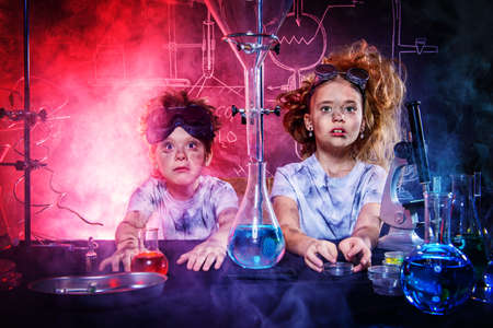 Funny school children doing experiments in the laboratory. Explosion in the laboratory. Science and education.の写真素材