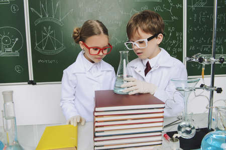 Two children scientists making experiments in the laboratory. Educational concept. Early development of children.の写真素材