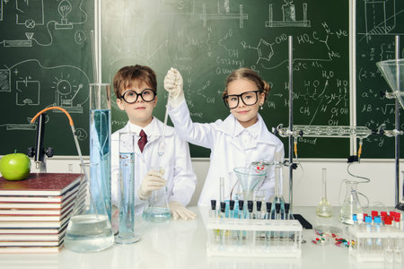 Two children scientists making experiments in the laboratory. Educational concept. Early development of children.の写真素材