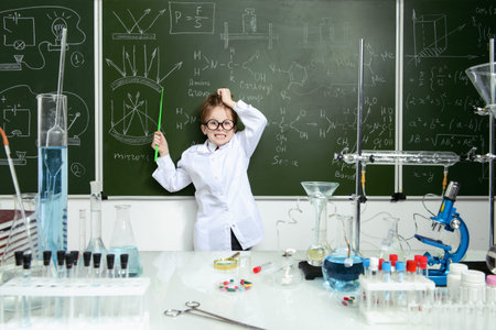 Funny school boy scientist in the laboratory. Educational concept.