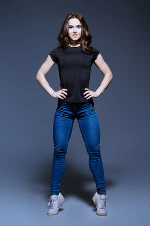 Athletic girl with perfect muscular body posing at studio in casual clothes. Beauty, fashion concept. Healthy lifestyle. の写真素材