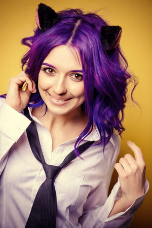 Portrait of a student girl with purple hair and cat's ears posing at studio. Japanese style anime. の写真素材