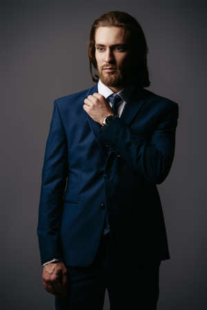 Fashion shot. Handsome young man posing in elegant blue suit and white shirt. Men's beauty, fashion.の写真素材