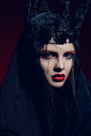 Portrait of a beautiful black princess with creative vivid makeup dressed in a black crown and veil....