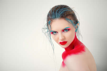 Portrait of a beautiful young woman with creative makeup and body painting. White background. Fashion and make-up concept.の写真素材