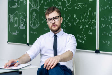 Young intelligent teacher conducts a chemistry lesson. Educational concept.の写真素材