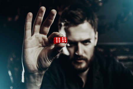 Gambler man at the game table shows the dice. Game of dice.の写真素材