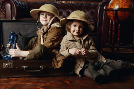 Traveler children in a travel suitcase are playing at home. Childhood. Fantasy, imagination. 