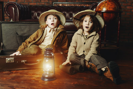 Traveler children in a travel suitcase are playing at home. Childhood. Fantasy, imagination. 