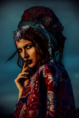 Beautiful fashion model posing in boho style clothes in the rays of the sunset. Outdoor fashion.の写真素材