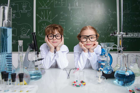 Two children scientists making experiments in the laboratory. Educational concept. Early development of children.の写真素材