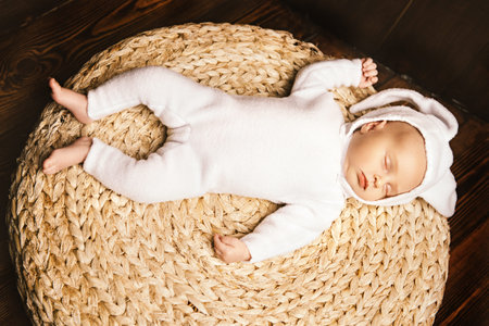 Cute newborn baby lies on a wooden background, dressed in rabbit costume. Easter holiday. Scenery in the rustic style.の写真素材