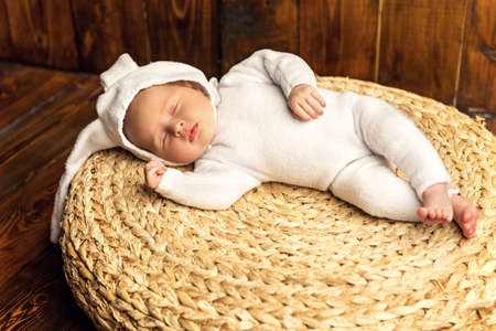 Cute newborn baby lies on a wooden background, dressed in rabbit costume. Easter holiday. Scenery in the rustic style.の写真素材