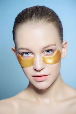 Close-up portrait of a beautiful young woman with collagen pads under her eyes. Spa, eye skin care.の写真素材