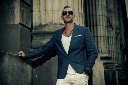 Smiling handsome mature man in stylish suit in the old town. Male beauty, fashion.の写真素材