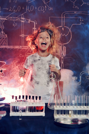 Funny little girl doing experiments in the laboratory. Explosion in the laboratory. Science and education.の写真素材
