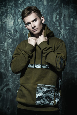 Portrait of a teenage boy over grunge background. Studio shot. Teen fashion.