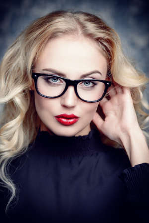 Beauty portrait. Attractive young woman in glasses with bright make-up. Optics style. Cosmetics and make-up. の写真素材