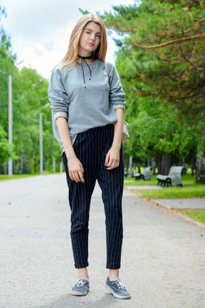 Portrait of a modern teen girl with long blonde hair posing outdoor. Beauty, fashion. Teen style.の写真素材