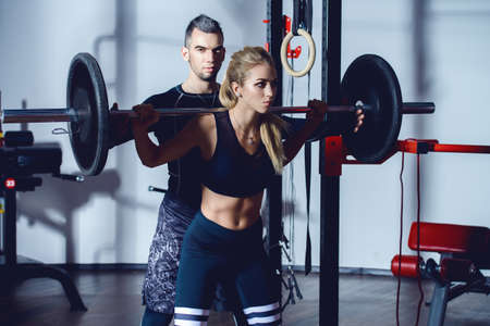 Portrait of muscular young people with beautiful athletic bodies in a gym. Fitness, bodybuilding. Health care.の写真素材