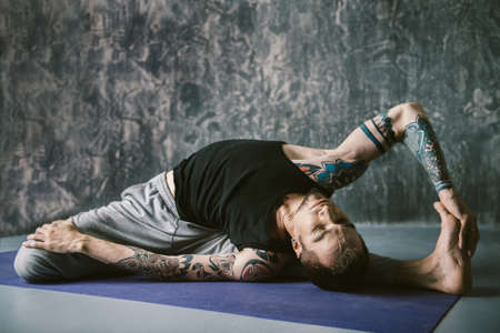An experienced yoga instructor showing different yoga poses over dark background. Healthy lifestyle. Meditation, concentration.の写真素材