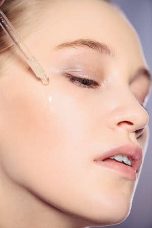 Portrait of a beautiful young a woman moisturizes her skin. Beauty, skincare cosmetology.の写真素材