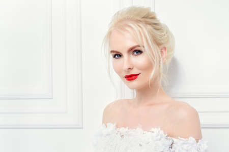 Portrait of a beautiful young woman in evening or wedding white dress. Evening hairstyle and makeup.の写真素材