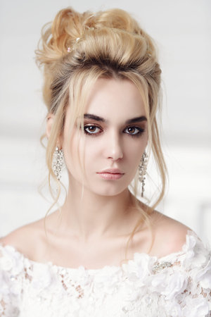 Close-up portrait of a beautiful bride woman. Wedding make-up and hairstyle. Jewellery.の写真素材