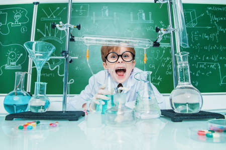 Funny school boy scientist in the laboratory. Educational concept.の写真素材