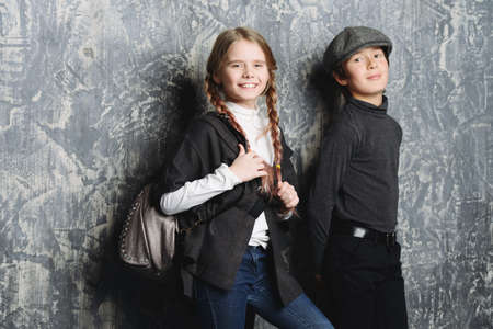 Kid's fashion. Two modern children posing together at studio. Clothes for children.の写真素材