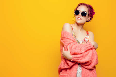 Beautiful girl with pink hair wearing bright clothes over yellow background. Bright style, fashion.の写真素材