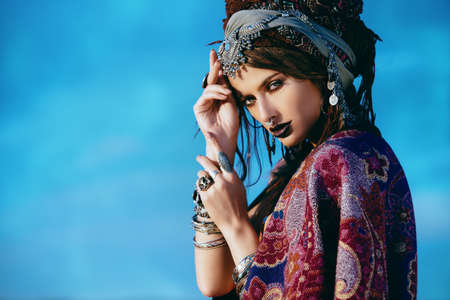 Beautiful fashion model posing in boho style clothes in the rays of the sunset. Outdoor fashion.の写真素材