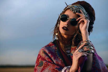 Magnificent fashion woman posing in boho style clothes in the rays of the sunset. Outdoor fashion....