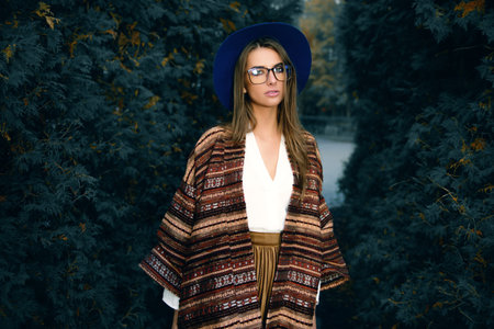 Fashion shot. Beautiful young woman in stylish clothes in the park. Ethnics, boho style.