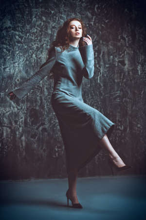 Modern  fifteen-year-old girl with long curly red hair is dancing in the studio. Beauty, fashion. Vogue dance.の写真素材