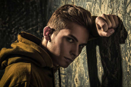 Portrait of a sad teenage boy over grunge background. Studio shot. Teen fashion.の写真素材