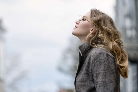 Modern young woman standing on a city street. Beauty, city fashion.の写真素材