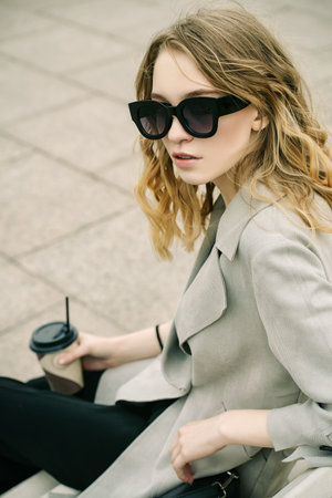 Modern young woman standing on a city street. Beauty, city fashion.の写真素材