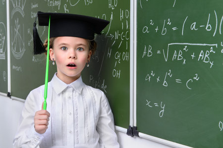 Clever schoolgirl stands by a chalkboard on a chemistry lesson. Educational concept.