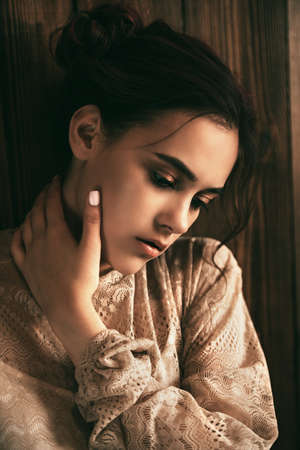 Modern teen girl posing by a wooden wall. Urban youth style. Adolescence, transition problems.の写真素材