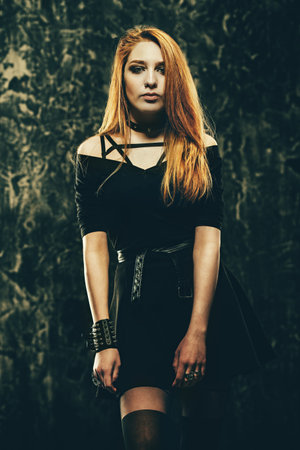 Magnificent woman in black gothic dress over grunge background. Fashion. Gothic style.