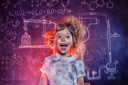 Funny little girl doing experiments in the laboratory. Explosion in the laboratory. Science and education.の写真素材