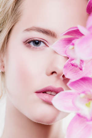 Close-up portrait of a beautiful romantic young woman with flowers. Cosmetics, healthcare. Beauty, fashion concept.の写真素材