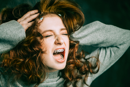 Expressive teen girl wearing dental braces. Emotions. Stomatology and orthodontics.の写真素材
